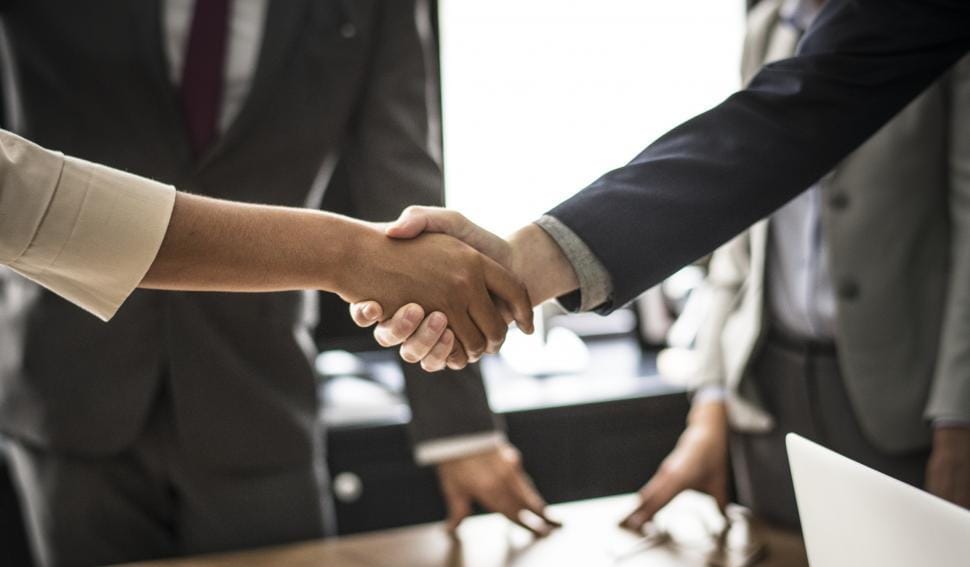 Business partners shaking hands after agreeing to work together